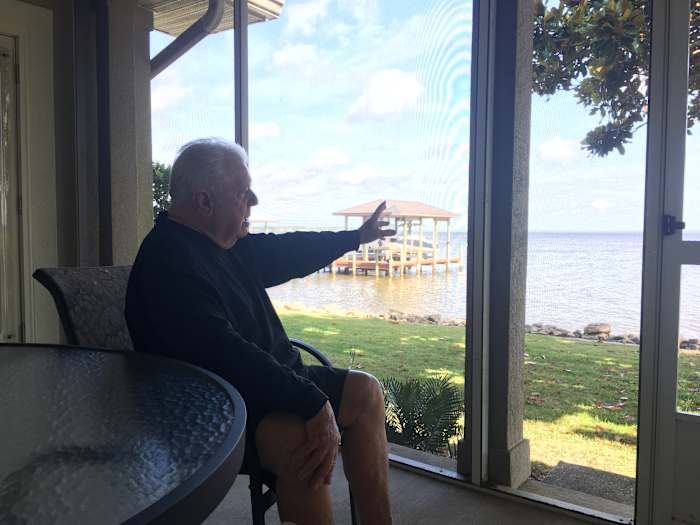 Pete Jenkins, a longtime SEC defensive line coach, gestures toward the bay from his home near the 30A area.